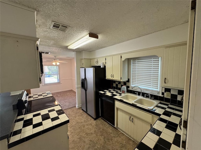 608 Roosevelt St, Seminole, OK 74868 - kitchen with visible vents, tile countertops, a sink, black dishwasher, and refrigerator with ice dispenser