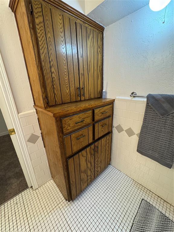 608 Roosevelt St, Seminole, OK 74868 - bathroom featuring tile patterned flooring and a wainscoted wall