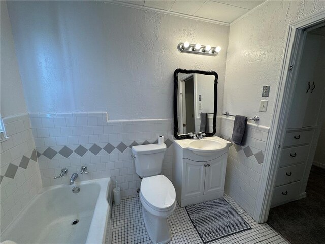 608 Roosevelt St, Seminole, OK 74868 - full bathroom featuring toilet, tile walls, tile patterned flooring, a garden tub, and vanity
