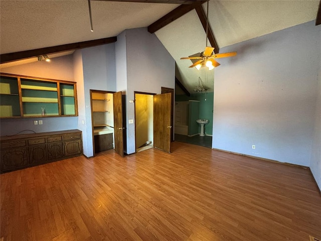 608 Roosevelt St, Seminole, OK 74868 - unfurnished living room with high vaulted ceiling, wood finished floors, a textured ceiling, ceiling fan, and beamed ceiling