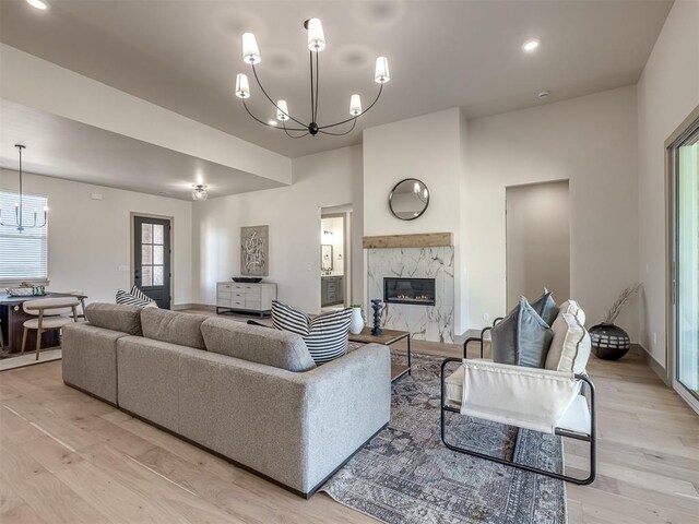 1529 Pedras Pl, Newcastle, OK 73065 - living room with a chandelier, light wood-style flooring, a high end fireplace, baseboards, and recessed lighting