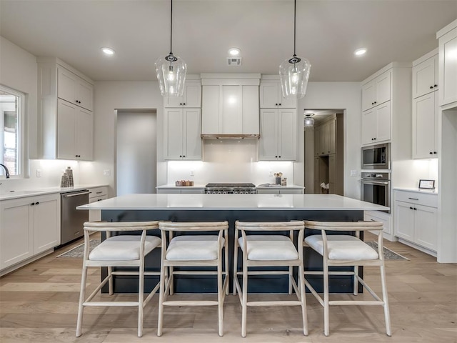 1529 Pedras Pl, Newcastle, OK 73065 - kitchen with appliances with stainless steel finishes, a center island, a kitchen bar, white cabinets, and recessed lighting