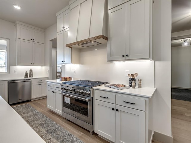 1529 Pedras Pl, Newcastle, OK 73065 - kitchen with premium range hood, appliances with stainless steel finishes, light wood-style floors, white cabinets, and light countertops