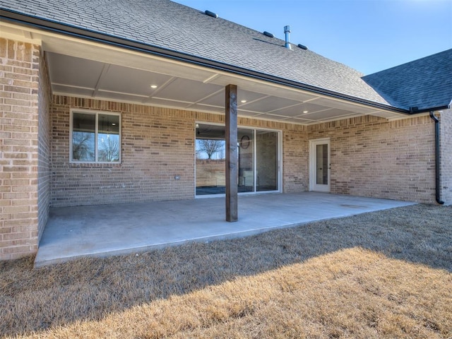 1529 Pedras Pl, Newcastle, OK 73065 - rear view of property featuring roof with shingles, brick siding, and a patio area