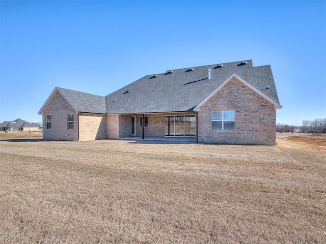 1529 Pedras Pl, Newcastle, OK 73065 - rear view of property with a shingled roof, brick siding, a lawn, and a patio