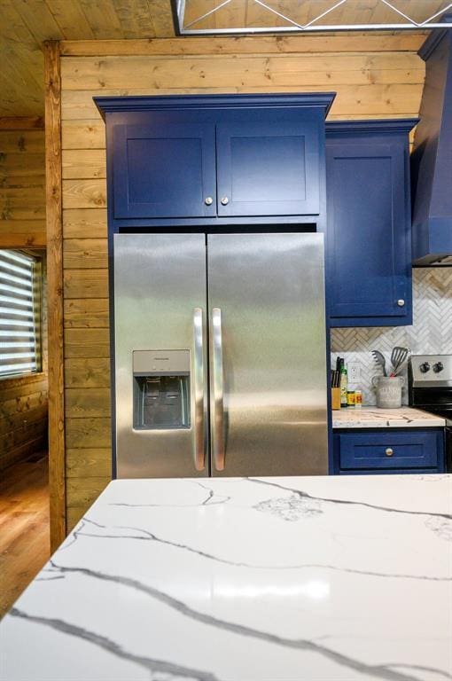 66 Morning Pines Trl, Broken Bow, OK 74728 - kitchen with wooden walls, appliances with stainless steel finishes, light stone counters, backsplash, and blue cabinets