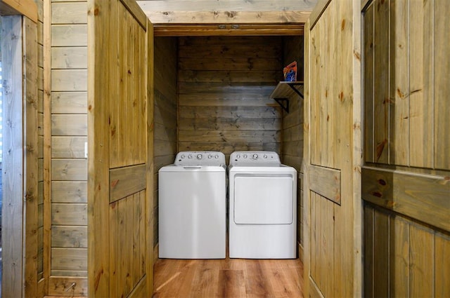 66 Morning Pines Trl, Broken Bow, OK 74728 - clothes washing area with wooden walls, laundry area, washer and clothes dryer, and light wood-style floors