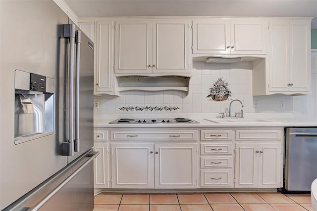 kitchen featuring appliances with stainless steel finishes, light countertops, white cabinets, and a sink