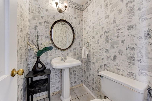 bathroom featuring wallpapered walls, toilet, tile patterned flooring, and baseboards