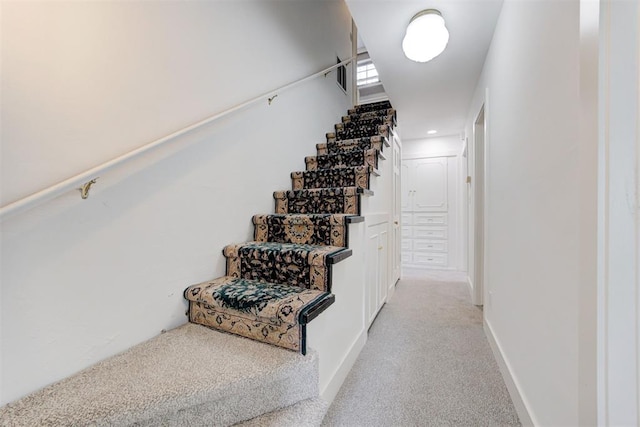 stairway featuring carpet and baseboards