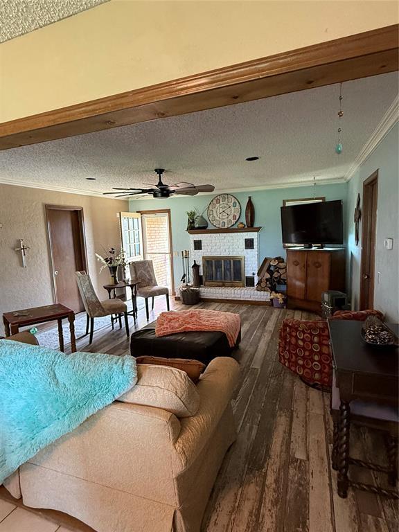 4108 N Broadway Ave, Hinton, OK 73047 - living room featuring crown molding, a textured ceiling, hardwood / wood-style floors, and a ceiling fan