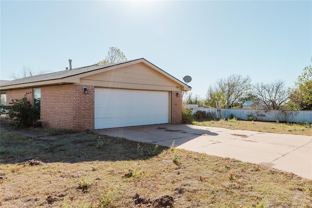4108 N Broadway Ave, Hinton, OK 73047 - view of side of home with fence, concrete driveway, an attached garage, and brick siding