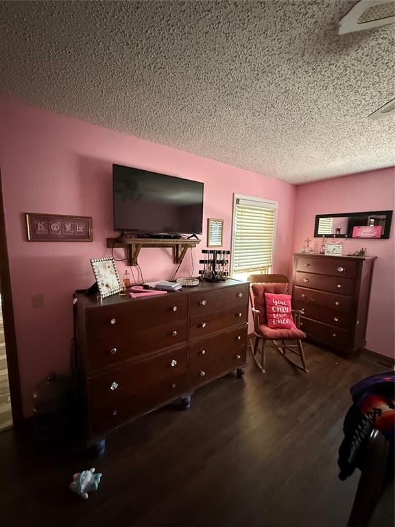 4108 N Broadway Ave, Hinton, OK 73047 - bedroom with a textured ceiling and dark wood finished floors