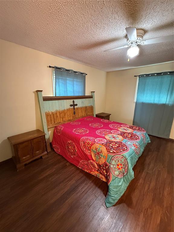 4108 N Broadway Ave, Hinton, OK 73047 - bedroom featuring ceiling fan, a textured ceiling, and dark wood-type flooring