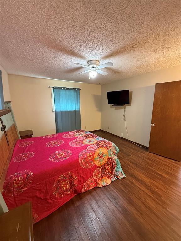 4108 N Broadway Ave, Hinton, OK 73047 - bedroom with wood finished floors, a ceiling fan, and a textured ceiling