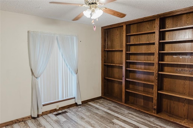 4108 N Broadway Ave, Hinton, OK 73047 - empty room with a textured ceiling, visible vents, baseboards, light wood-type flooring, and a ceiling fan