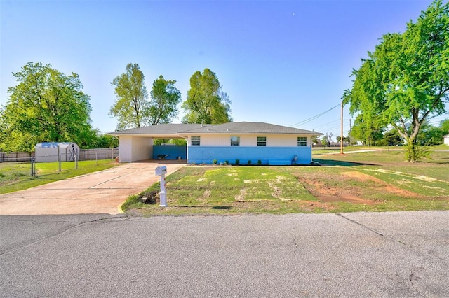 ranch-style home featuring fence, driveway, a front lawn, and a carport