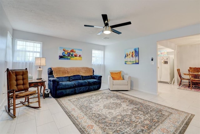 living room with ceiling fan, a healthy amount of sunlight, and light tile patterned floors