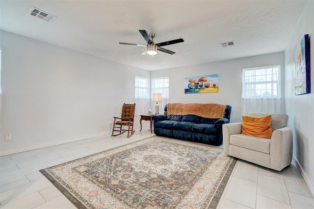tiled living area with plenty of natural light, a ceiling fan, and visible vents