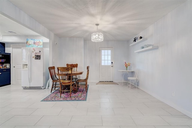 dining area featuring an inviting chandelier, visible vents, and baseboards