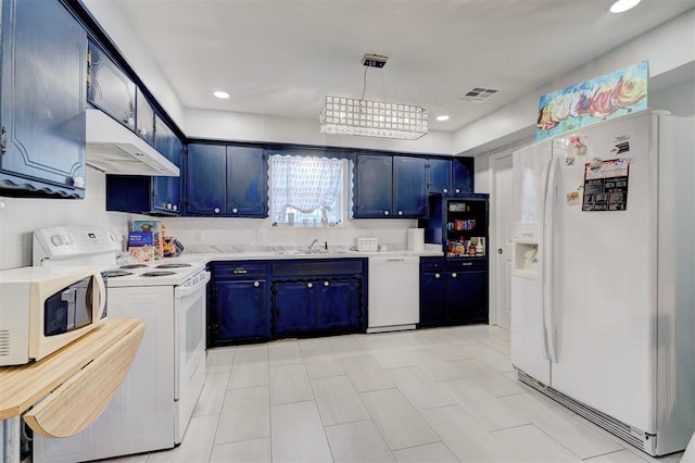 kitchen featuring white appliances, light countertops, blue cabinetry, under cabinet range hood, and visible vents