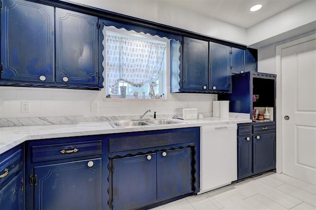 kitchen featuring blue cabinets, white dishwasher, light countertops, and a sink