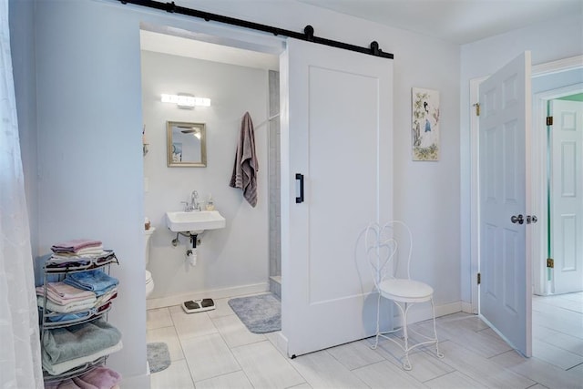 bathroom featuring baseboards, a sink, and toilet