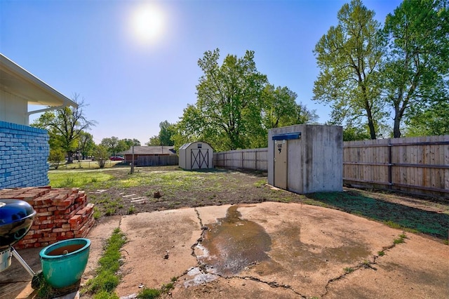 view of yard featuring a storage unit, an outbuilding, and a fenced backyard