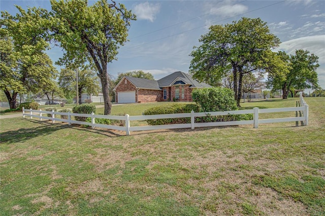 ranch-style house with a garage, fence private yard, driveway, and a front lawn