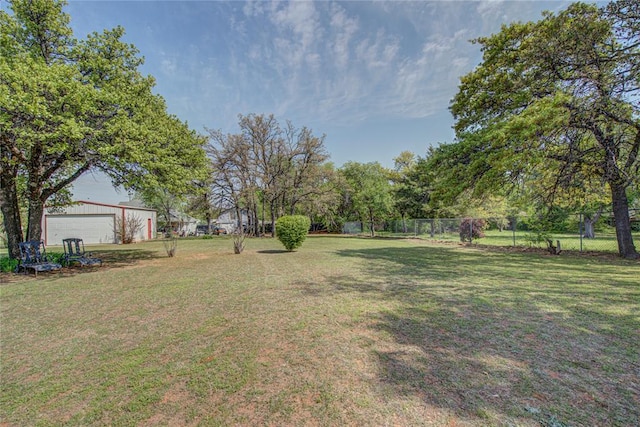 view of yard featuring an outdoor structure, fence, and a detached garage