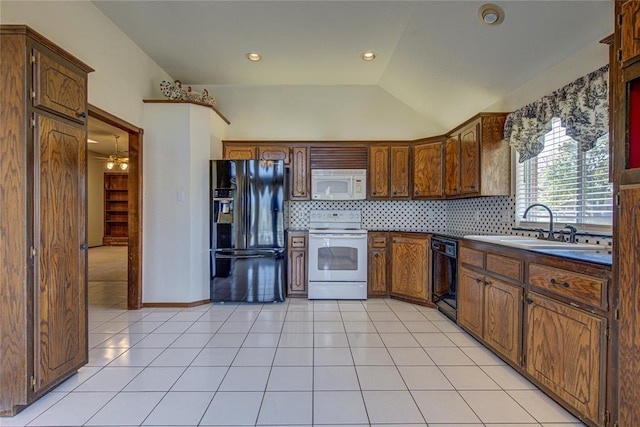 kitchen with tasteful backsplash, a sink, black appliances, light tile patterned flooring, and lofted ceiling