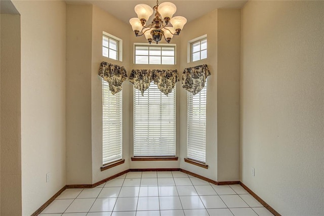interior space featuring baseboards, a chandelier, and light tile patterned floors