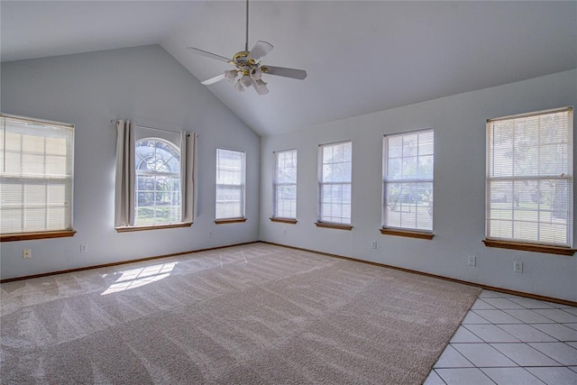 empty room with high vaulted ceiling, a wealth of natural light, baseboards, and ceiling fan