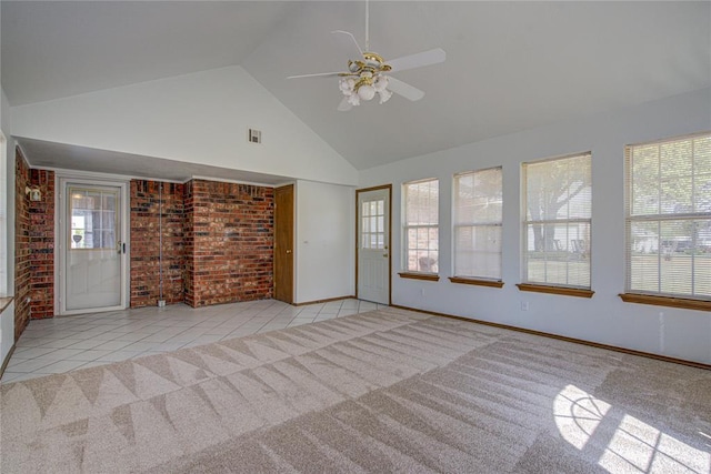 unfurnished living room with high vaulted ceiling, brick wall, ceiling fan, and carpet