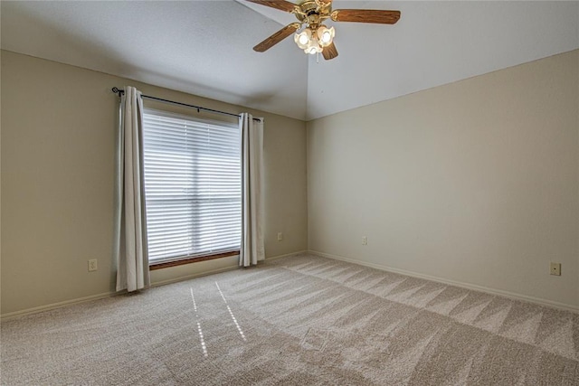 spare room with carpet floors, lofted ceiling, baseboards, and ceiling fan
