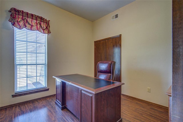 office with visible vents, dark wood-type flooring, and a healthy amount of sunlight