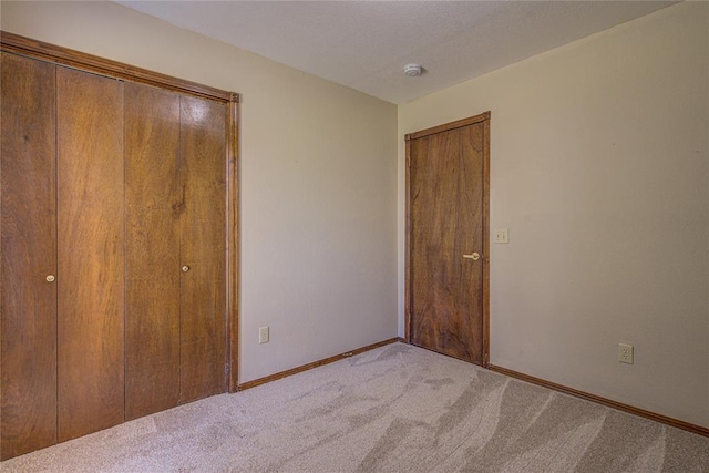 unfurnished bedroom featuring carpet floors and baseboards