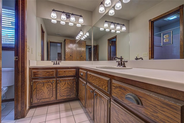 full bath with double vanity, tile patterned flooring, toilet, and a sink