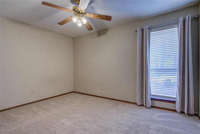 empty room featuring baseboards, light colored carpet, and ceiling fan