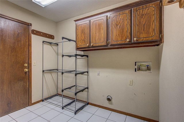 laundry room featuring light tile patterned floors, gas dryer hookup, hookup for a washing machine, baseboards, and cabinet space