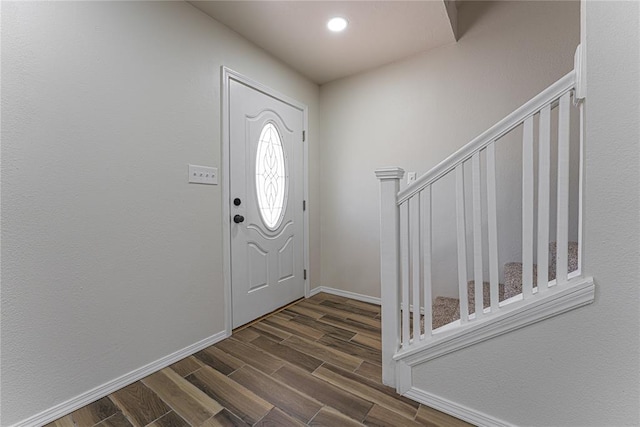 foyer with baseboards and dark wood-style flooring
