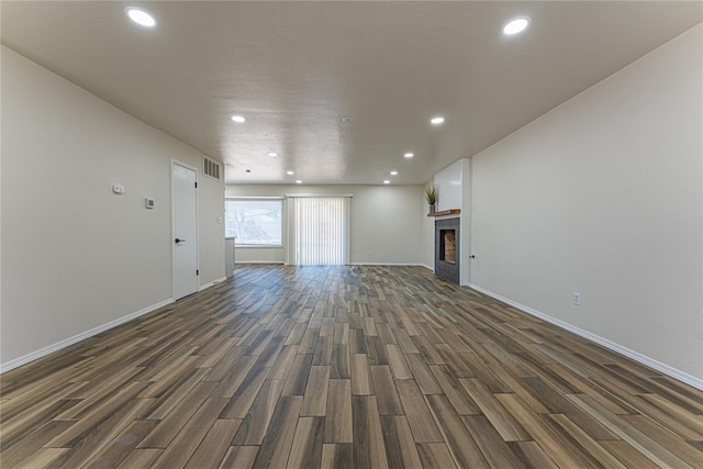 unfurnished living room with recessed lighting, baseboards, visible vents, and dark wood-style floors