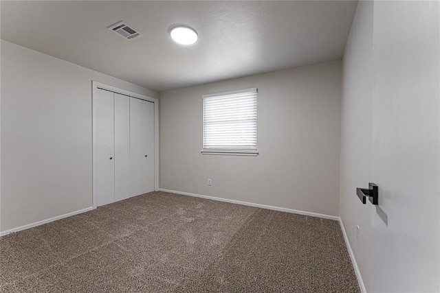 unfurnished bedroom featuring baseboards, a closet, visible vents, and carpet