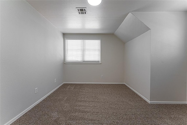 additional living space with lofted ceiling, baseboards, visible vents, and carpet floors