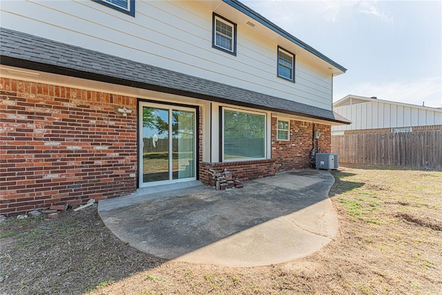 back of house with fence, a patio area, brick siding, and central air condition unit