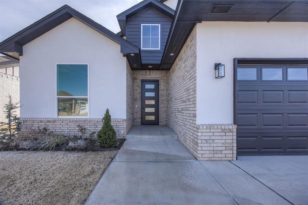 property entrance with stucco siding and brick siding