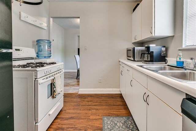 1115 W Eufaula St, Norman, OK 73069 - kitchen with light countertops, white cabinetry, appliances with stainless steel finishes, and dark wood-style flooring