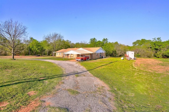 view of front facade with a carport, a front lawn, and driveway