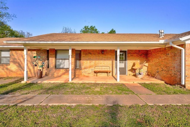 exterior space featuring brick siding and a front lawn