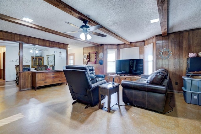 living area with a textured ceiling, a ceiling fan, and beam ceiling